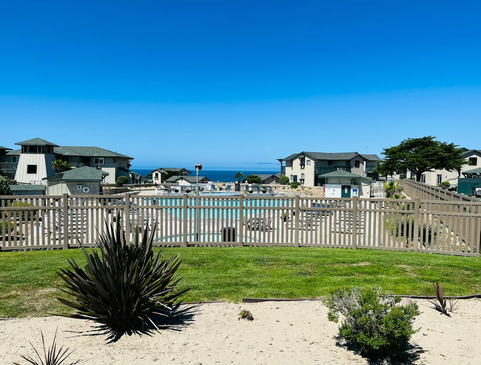Resort buildings and pool with ocean view in Marina, California.